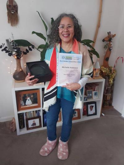 A picture of Michelle Hubbard holding her Best Wildlife Garden winners trophy and certificate